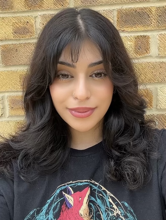A student in front of a brick wall